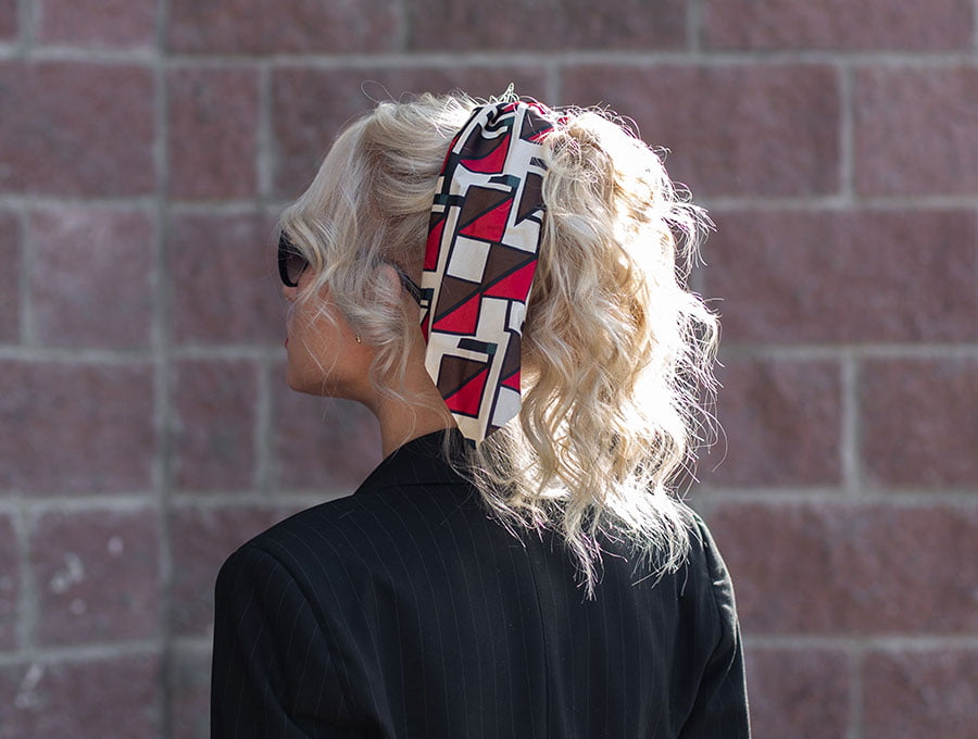 Mujer con cabello decolorado lleva un bonito pañuelo en la cabeza.
